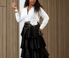 Classic silhouettes elevated by tiered satin layers and refined accessories. K&R Thread black satin tiered maxi skirt styled with a white collared shirt and floral waist detail.