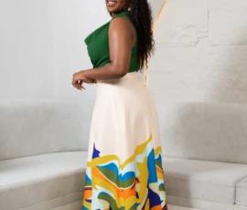 Designed for effortless movement and grace. Side profile view of a woman wearing a flowy abstract print maxi skirt and green top, showcasing the fabric movement.