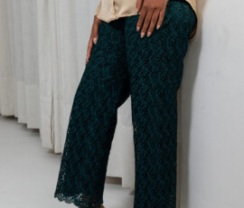 Premium floral lace craftsmanship with a delicate scalloped hem. Close up of the intricate floral lace detail on emerald green wide-leg pants by K&R Thread.