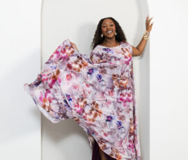 A breathtaking display of floral artistry designed for movement and grace. K&R Thread purple orchid print sheer maxi dress with flowing sleeves and gold accessories.